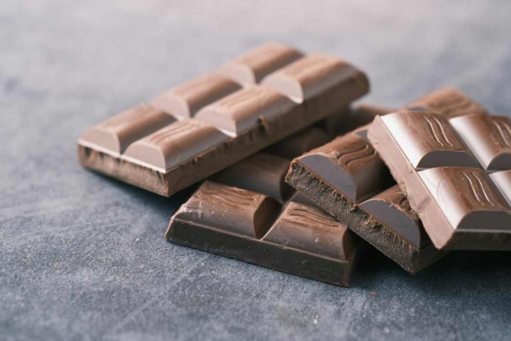 An image of 4 pieces of chocolate on a table depicting Chocolate Toxicity in Dogs.